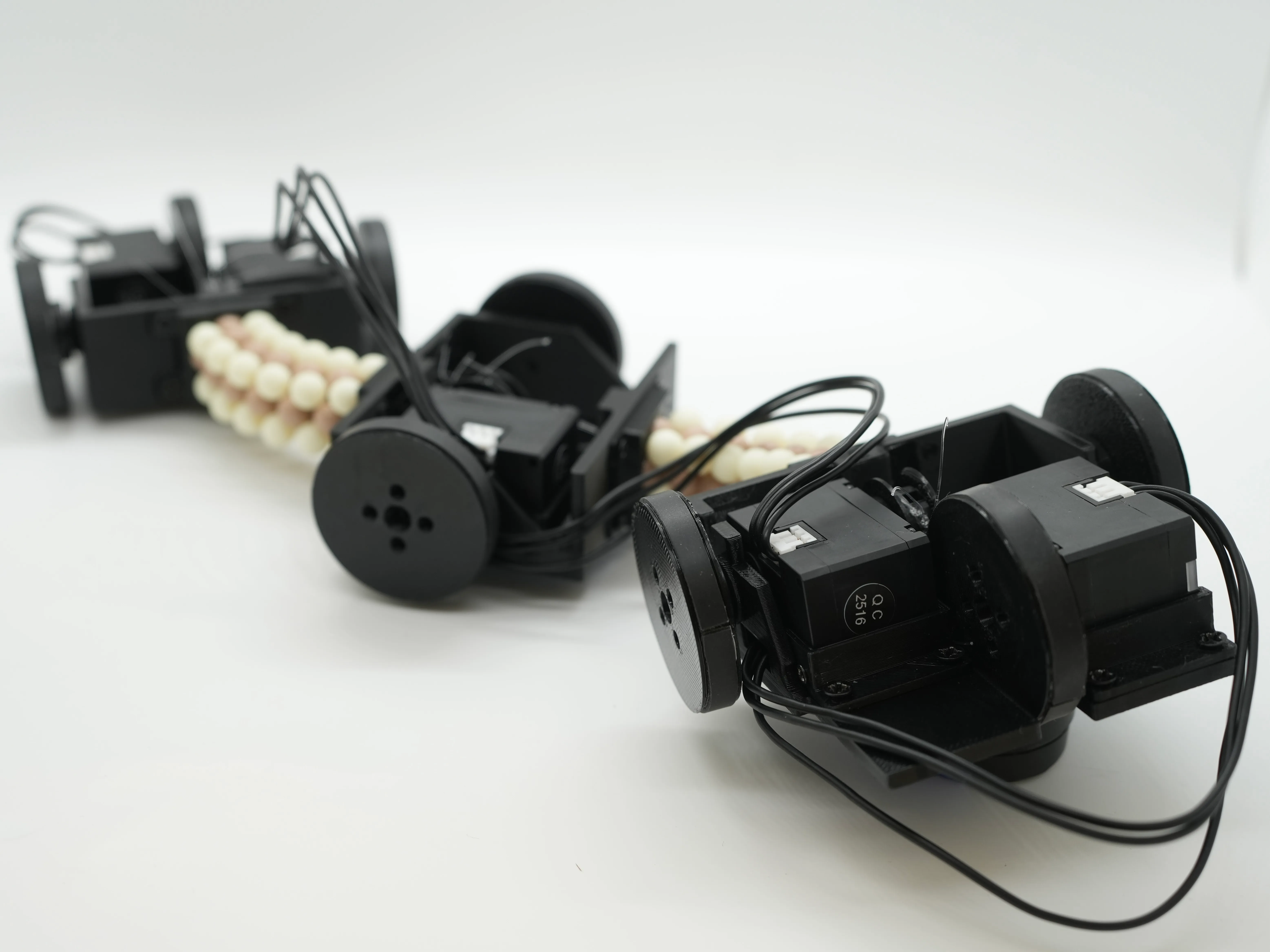 3つの車輪モジュールを2つのビーズ状スパインで接続した腱駆動移動ロボット
