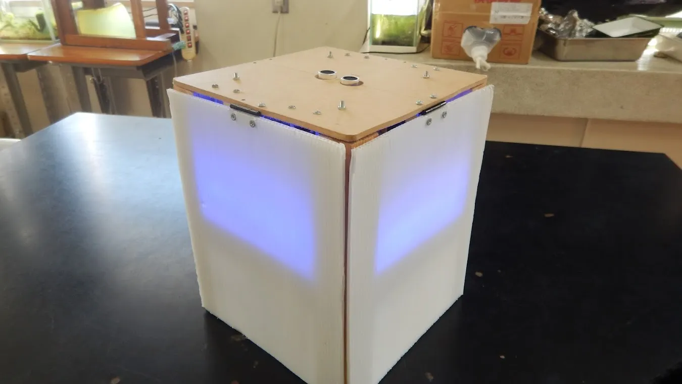 A white box-shaped target device glowing blue