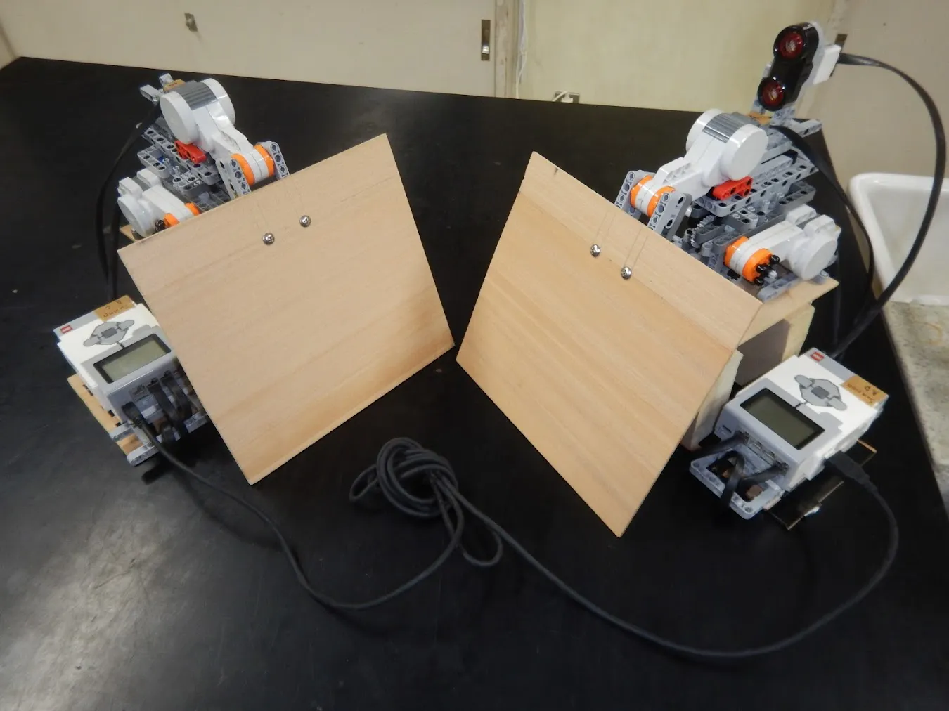 木製の瓦を構えた2台のLEGOロボット