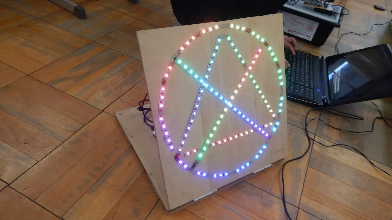 A wooden judging device displaying a pattern with multicolored LED strips