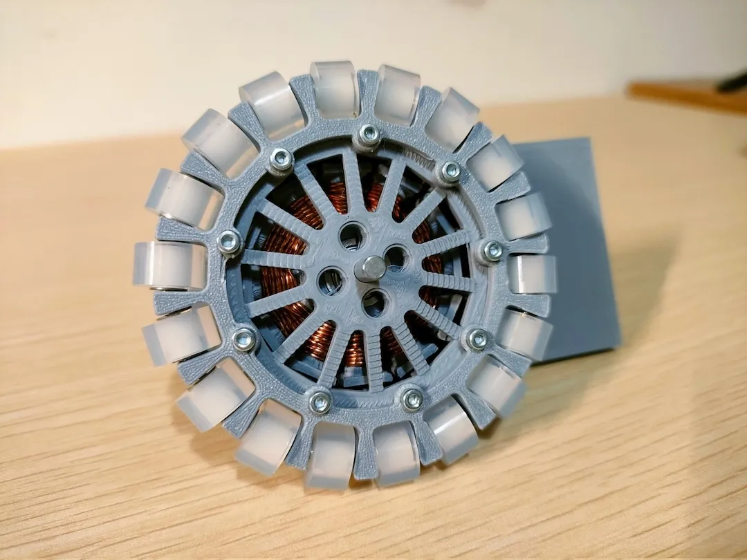 銅線のコイルと白いローラーが見える灰色の3Dプリンタ製モーター正面