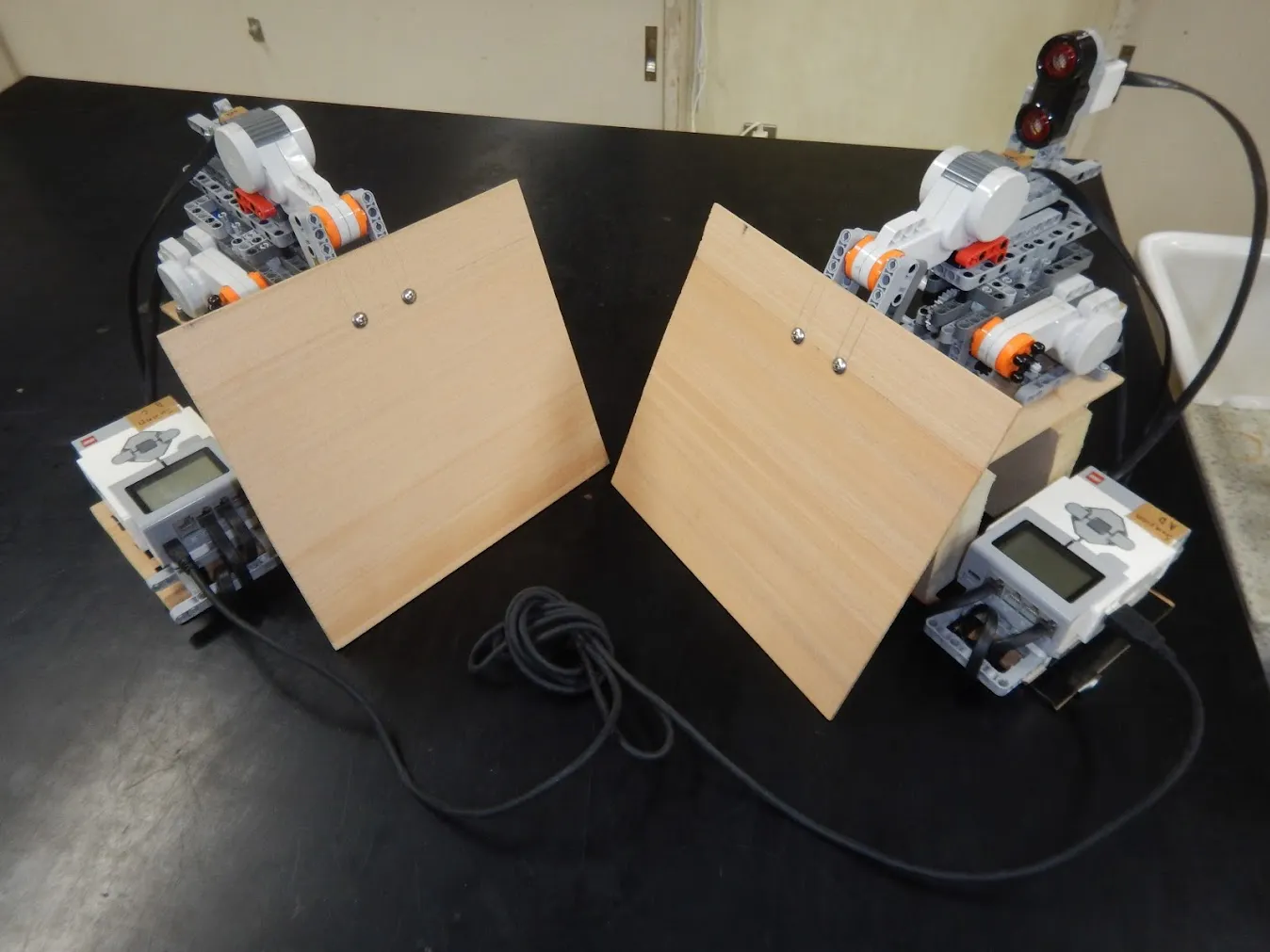 木製の瓦を構えた2台のLEGOロボット