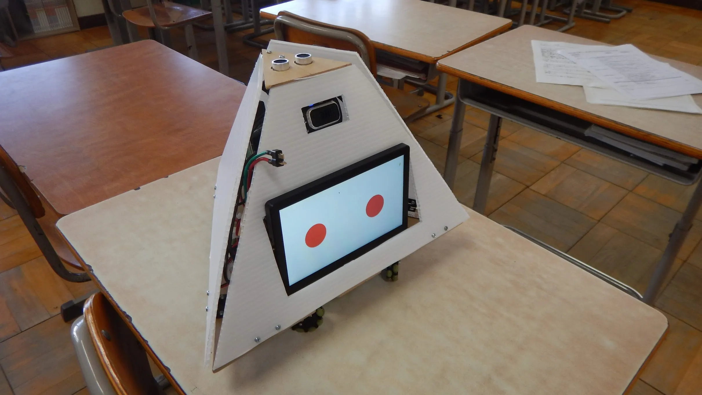 Maou, a triangular robot with a display on its front